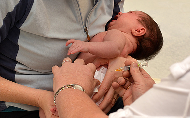 A one day old baby boy having his first injection